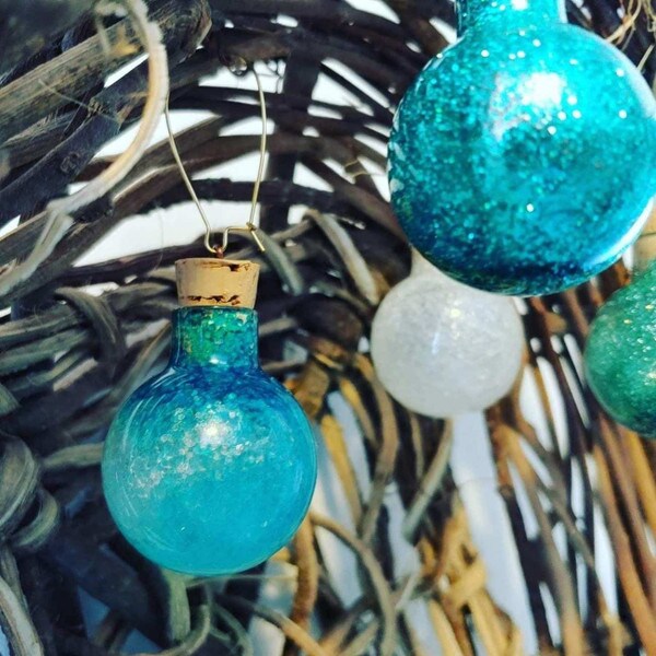 Small SL tapered cork in handmade blue glitter ornament hanging on a pine tree.